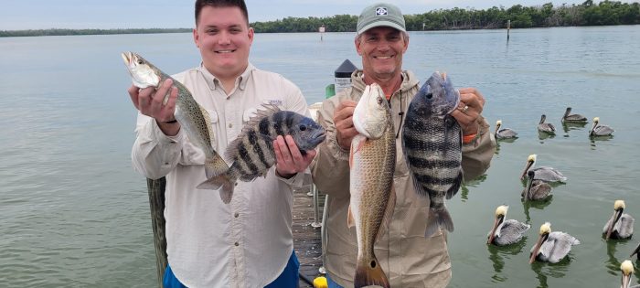 Pat and Ken hold up several of the cooler full of redfish, sheepshead and trout they caught